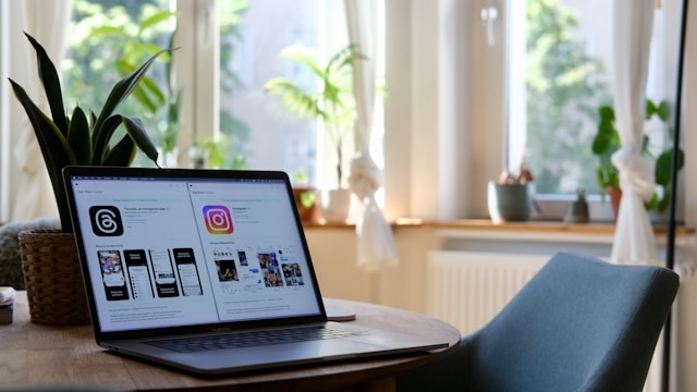 A Macbook screen displays the App Store preview pages for both Threads and Instagram, side by side. 