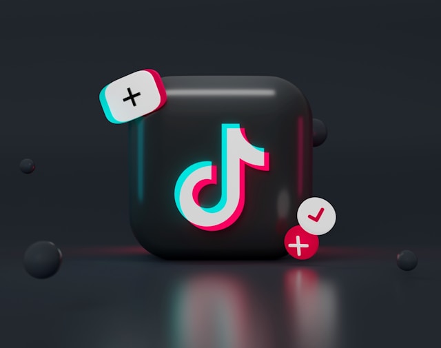 A 3D TikTok logo with glowing cyan and red accents, surrounded by plus and checkmark symbols on a dark background.