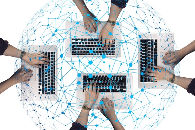Multiple hands typing on laptops connected by blue network lines.