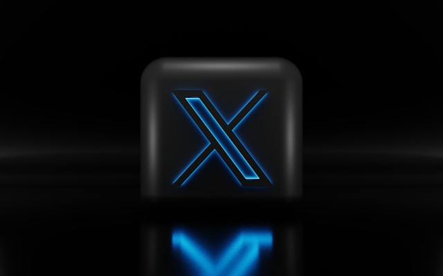 A sleek black cube with a glowing blue "X" symbol, set against a dark reflective background.