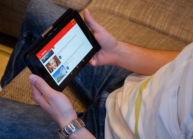 A person holding a tablet, browsing a video on YouTube.