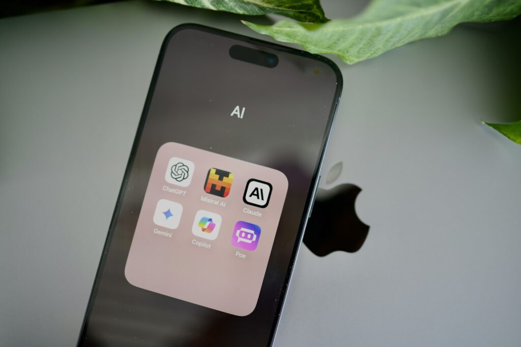 A black iPhone with a folder containing several AI-powered chatbots.